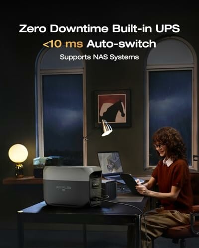 Person using laptop with built-in UPS system in dimly lit room.